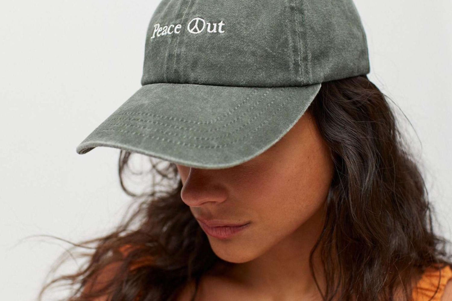 Model wearing phrase embroidered baseball hat with curved brim