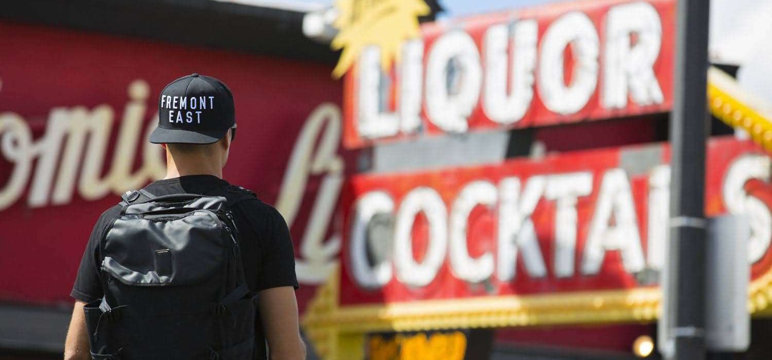 black-snapback-3d-embroidery-fremont-east-streetwear. Black structured snapback hat with white 3D embroidery “FREMONT EAST” on front panel, worn outdoors in urban street style