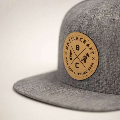 Heather grey snapback hat with debossed leather patch "BOTTLECRAFT BEER SHOP", custom headwear