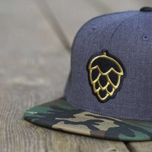 Heather navy snapback with camouflage brim and gold 3D puff embroidery hop cone logo