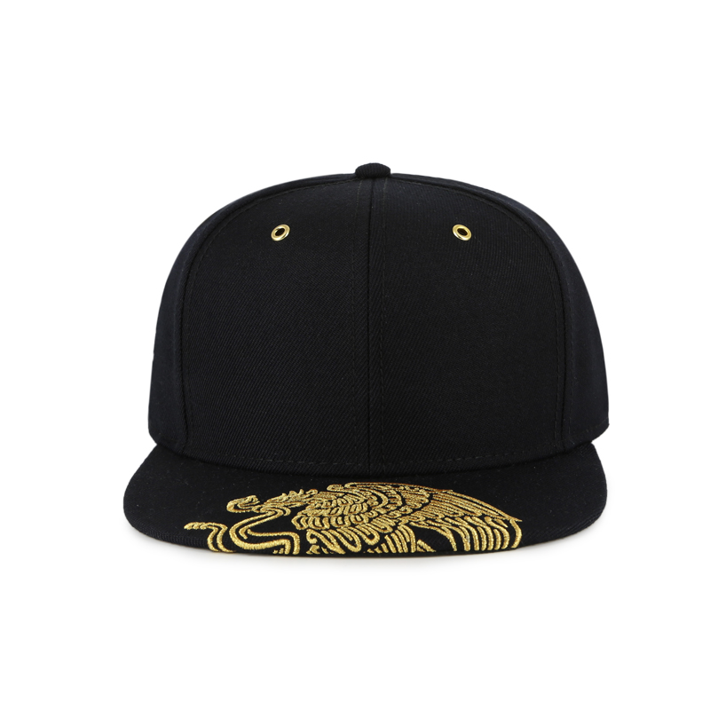 Front view of a black 6-panel structured flat bill snapback featuring gold metallic embroidery on the visor and gold metal grommets.