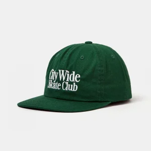 Angled front view of an unstructured forest green cotton twill 6-panel cut-and-sew dad hat featuring a flat brim and crisp high-density white "City Wide Skate Club" embroidery.