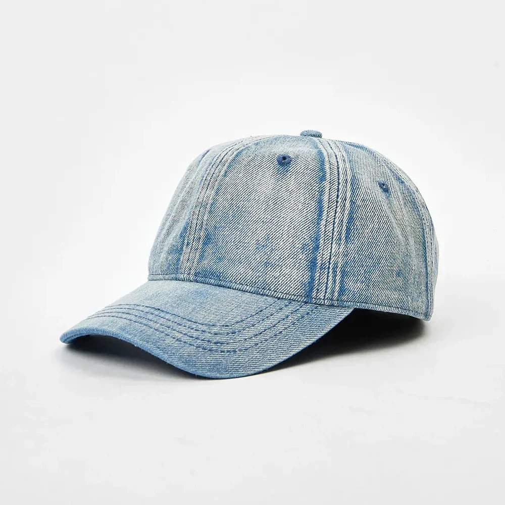 Angled front view of an unstructured light blue washed denim 6-panel dad hat featuring a pre-curved brim and vintage acid wash texture.