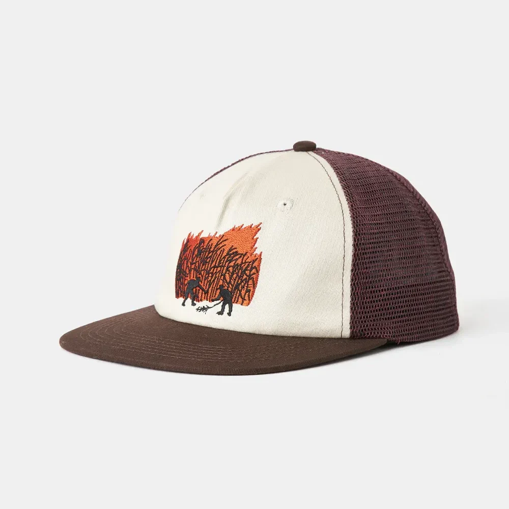 Angled front view of a cream and brown trucker hat with a maroon mesh back, flat brim, and orange/black graphic embroidery on the front panel.