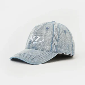 Front three-quarter view of a light wash denim unstructured 6-panel dad cap featuring white flat embroidery spanning the front center seam, with visible curved brim profile and faded denim texture.