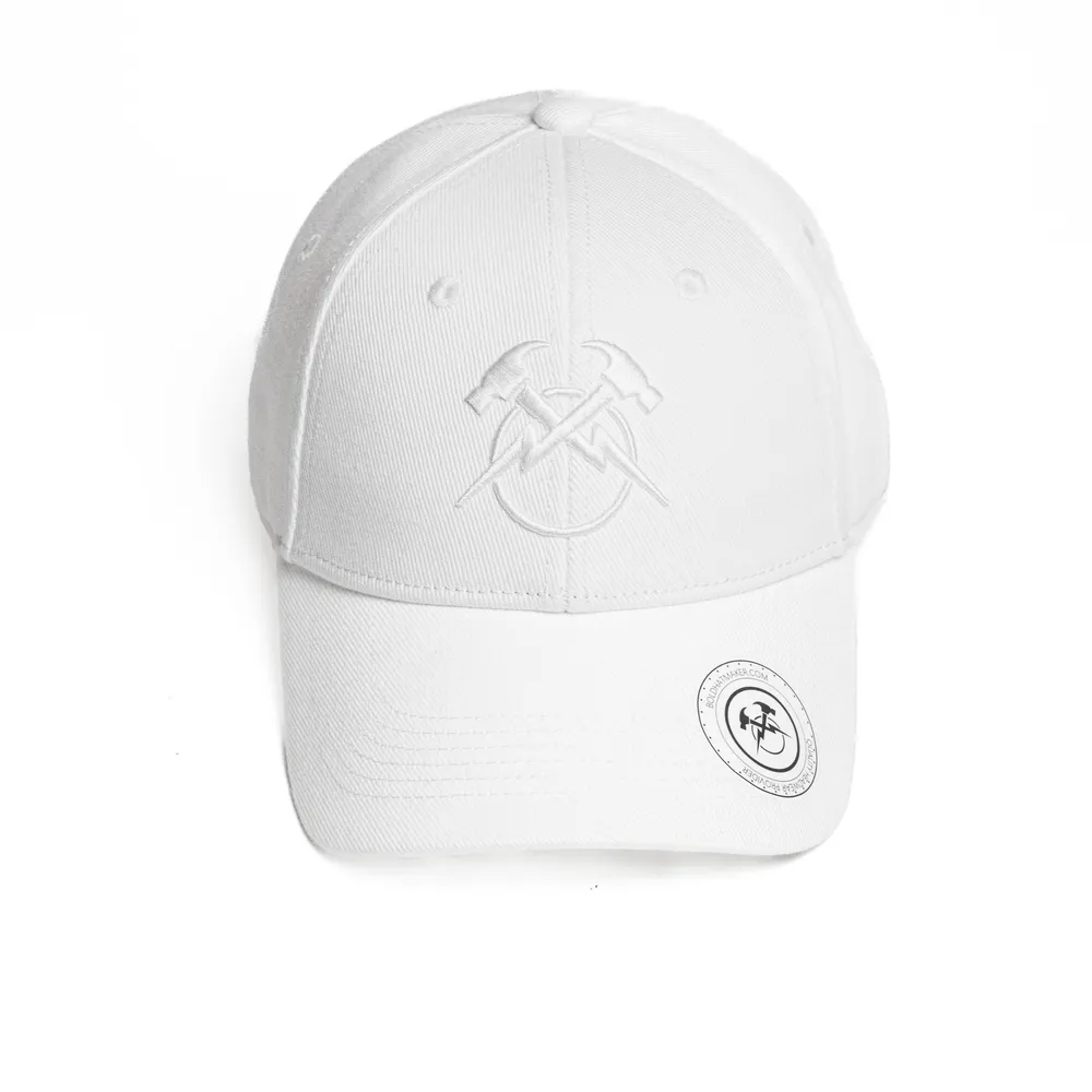 Direct front view of a white unstructured cotton twill dad hat displaying centered tonal white flat embroidery across the front seam, a circular black-and-white branded sticker on the pre-curved brim, and soft low-profile crown structure.
